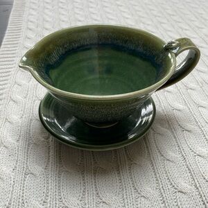 Pottery bowl with spout/handle & saucer. Blues and greens glazed Makers mark